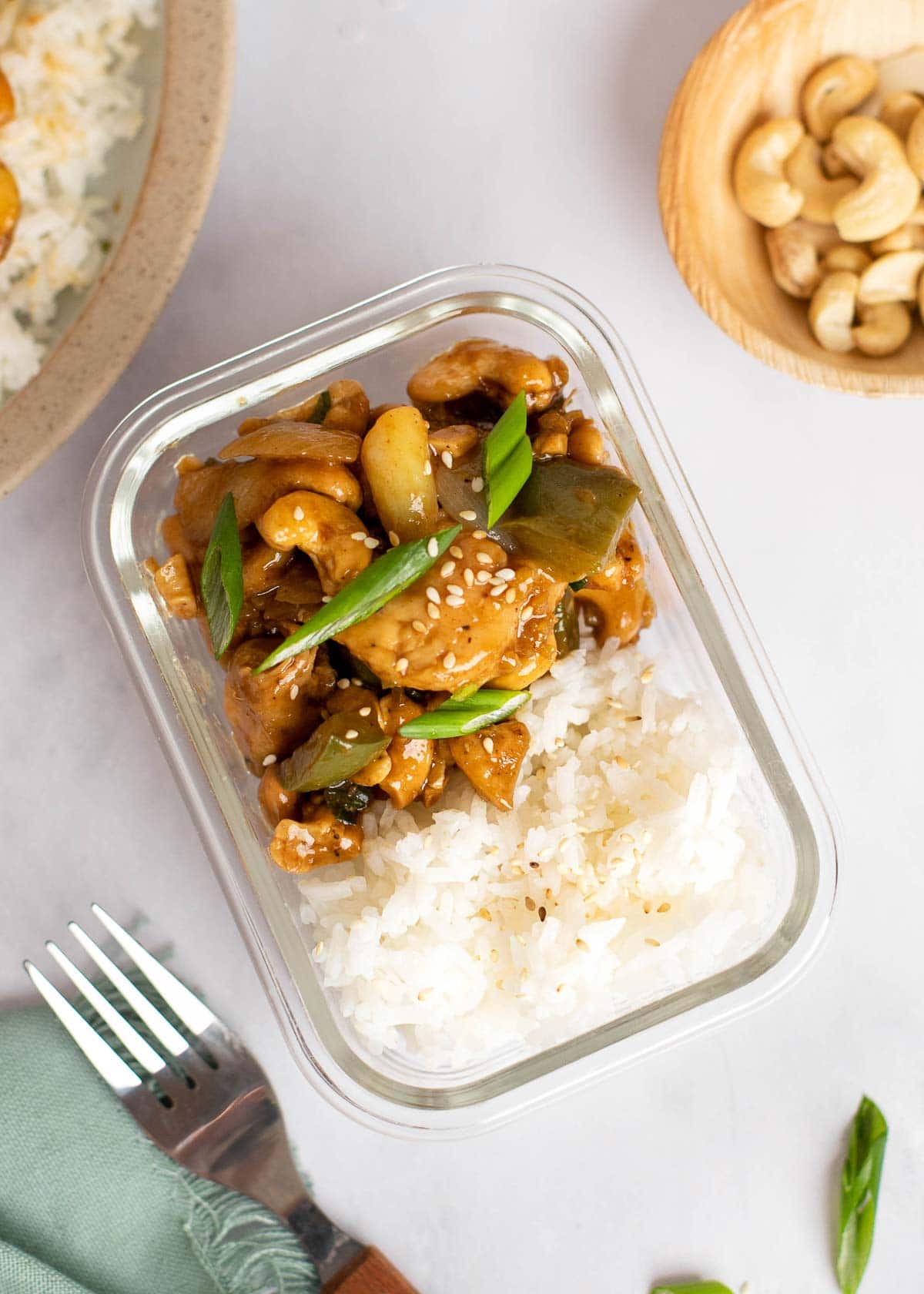 cashew chicken and rice in a glass storage container