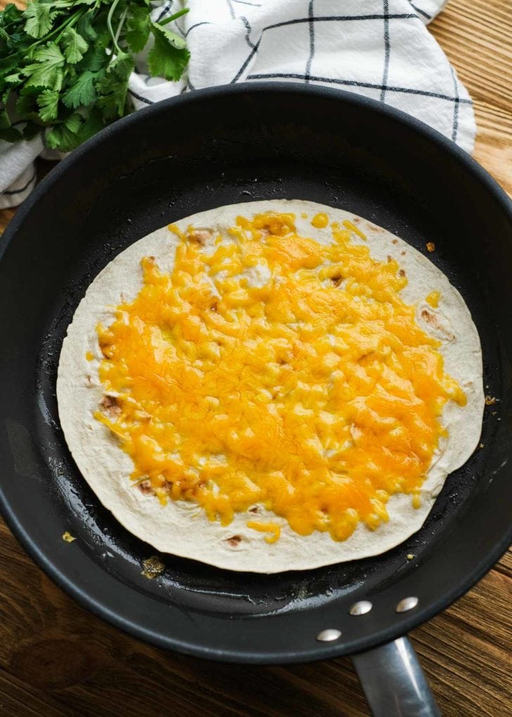 melted cheese on tortilla in a skillet