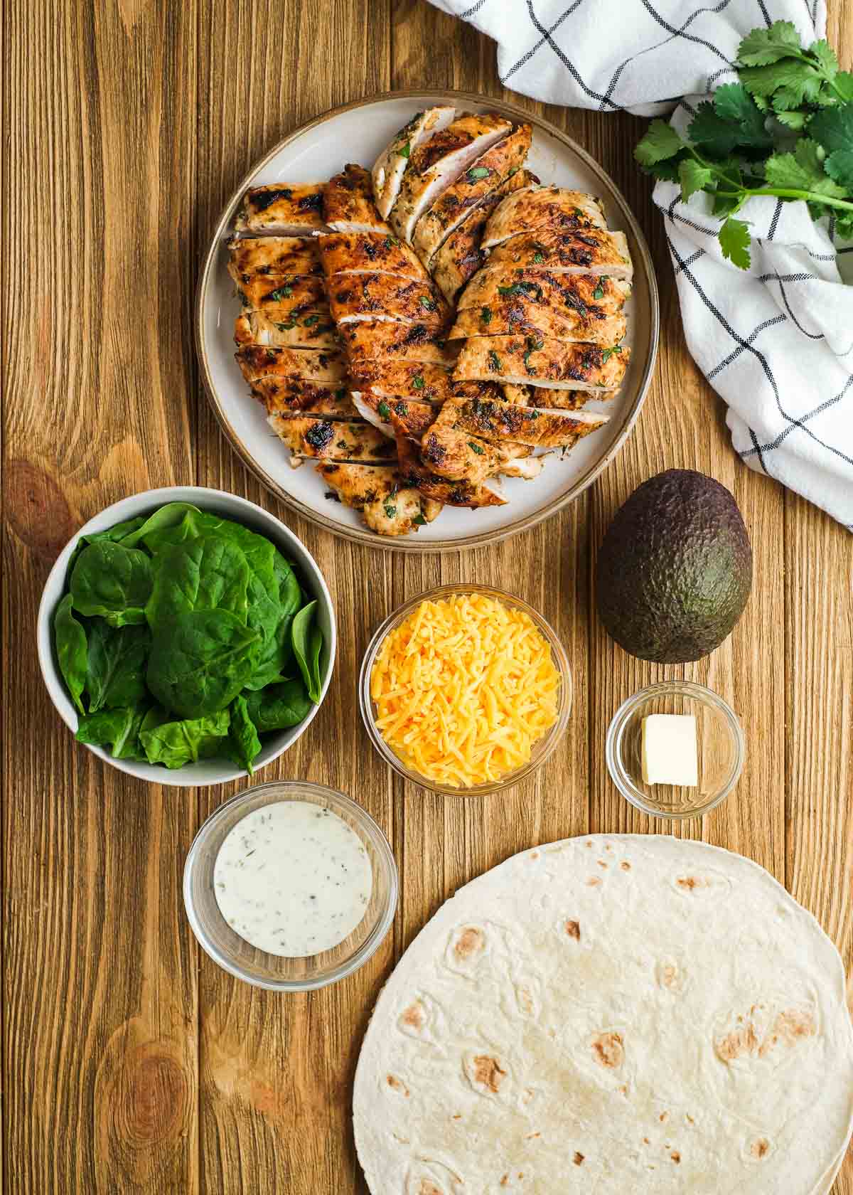 chicken avocado wrap ingredients on a wooden cutting board