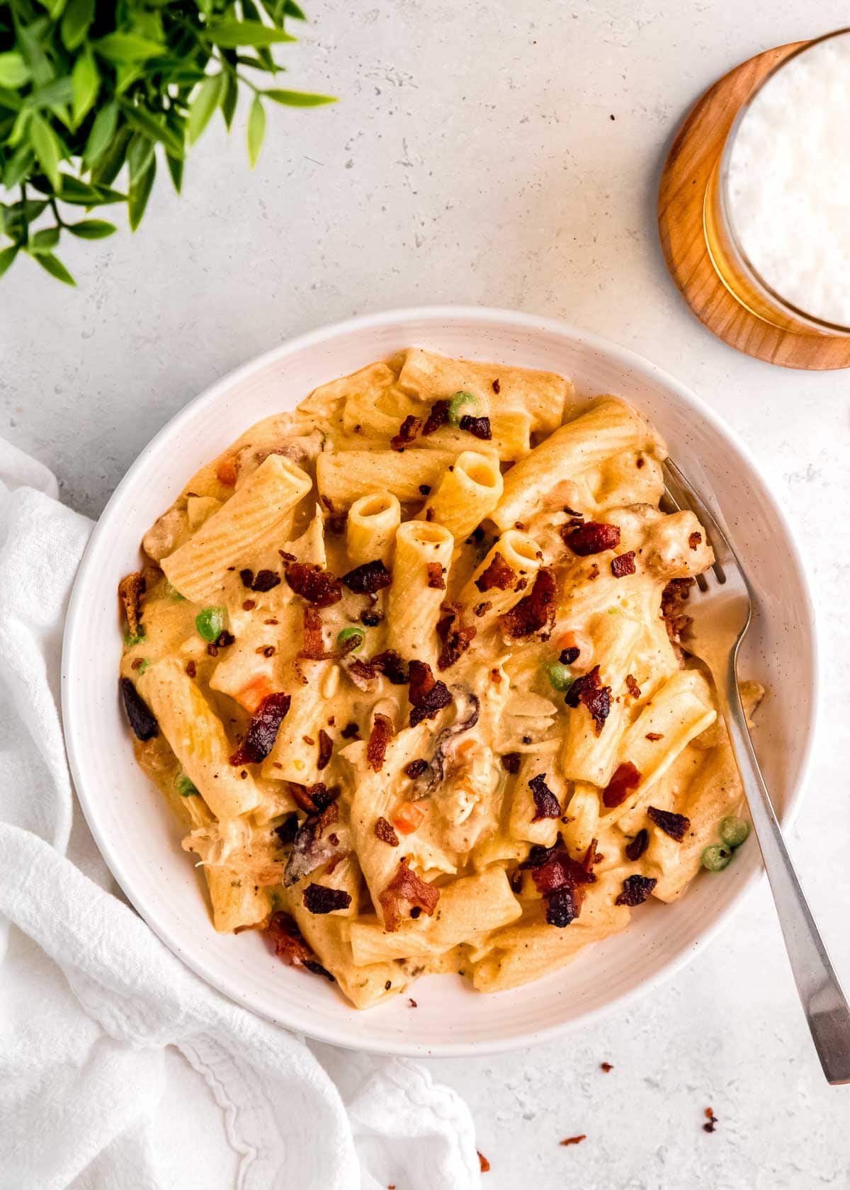 overhead view of white bowl full of creamy chicken bacon ranch pasta