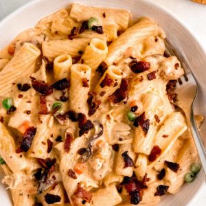 close up overhead image of chicken bacon ranch pasta and fork in white bowl