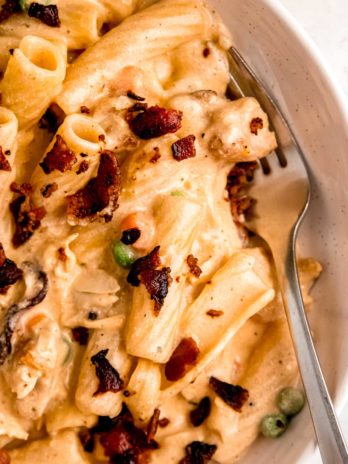 close up image of chicken bacon ranch pasta and fork in white bowl