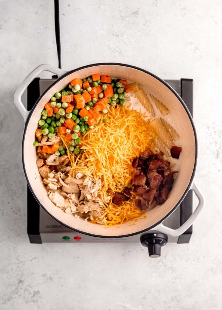 overhead image of chicken bacon ranch pasta ingredients in a dutch oven