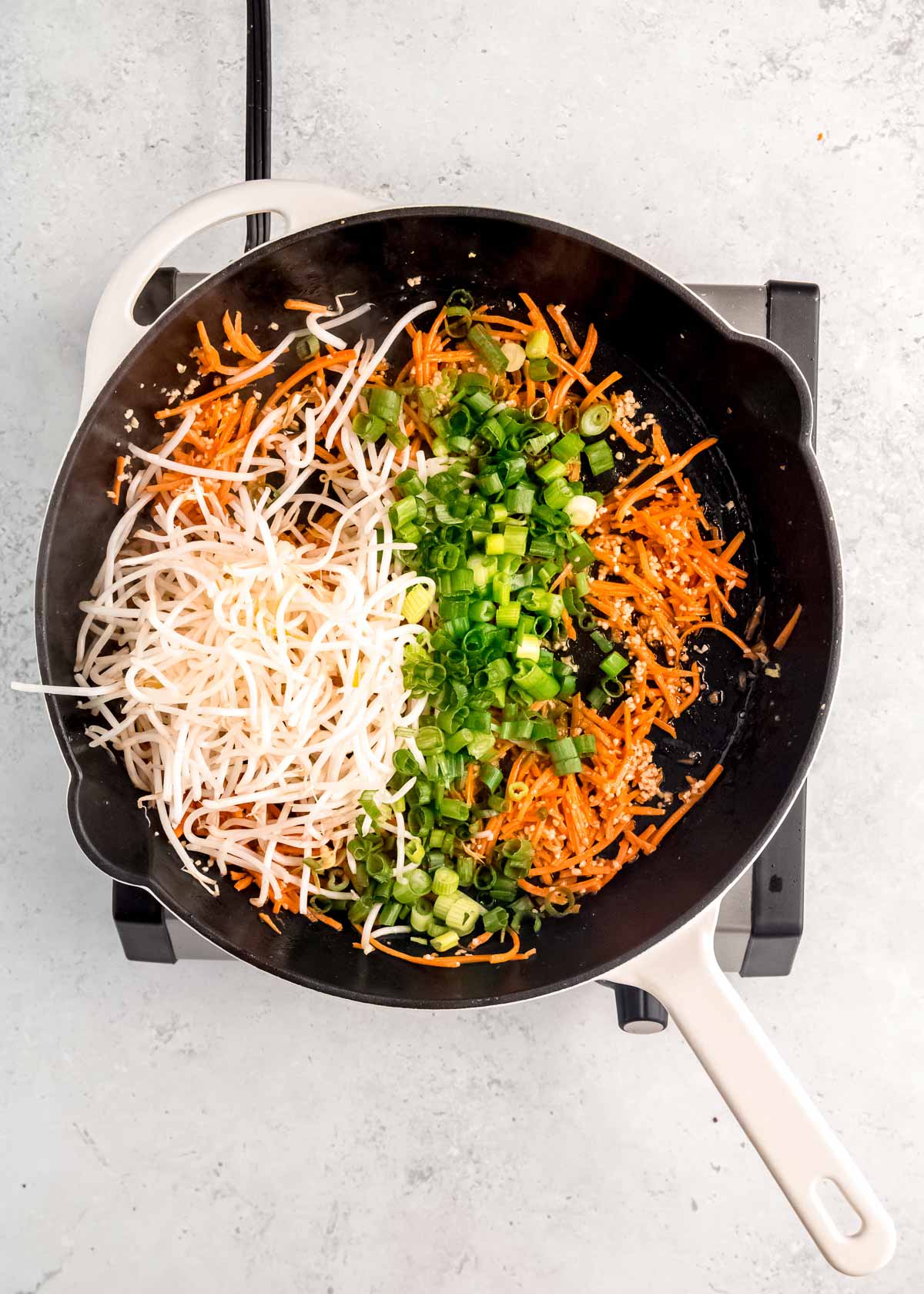 overhead image of vegetables being sauteed in skillet