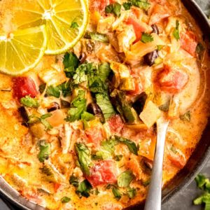 close up image of chicken poblano soup and spoon in black bowl