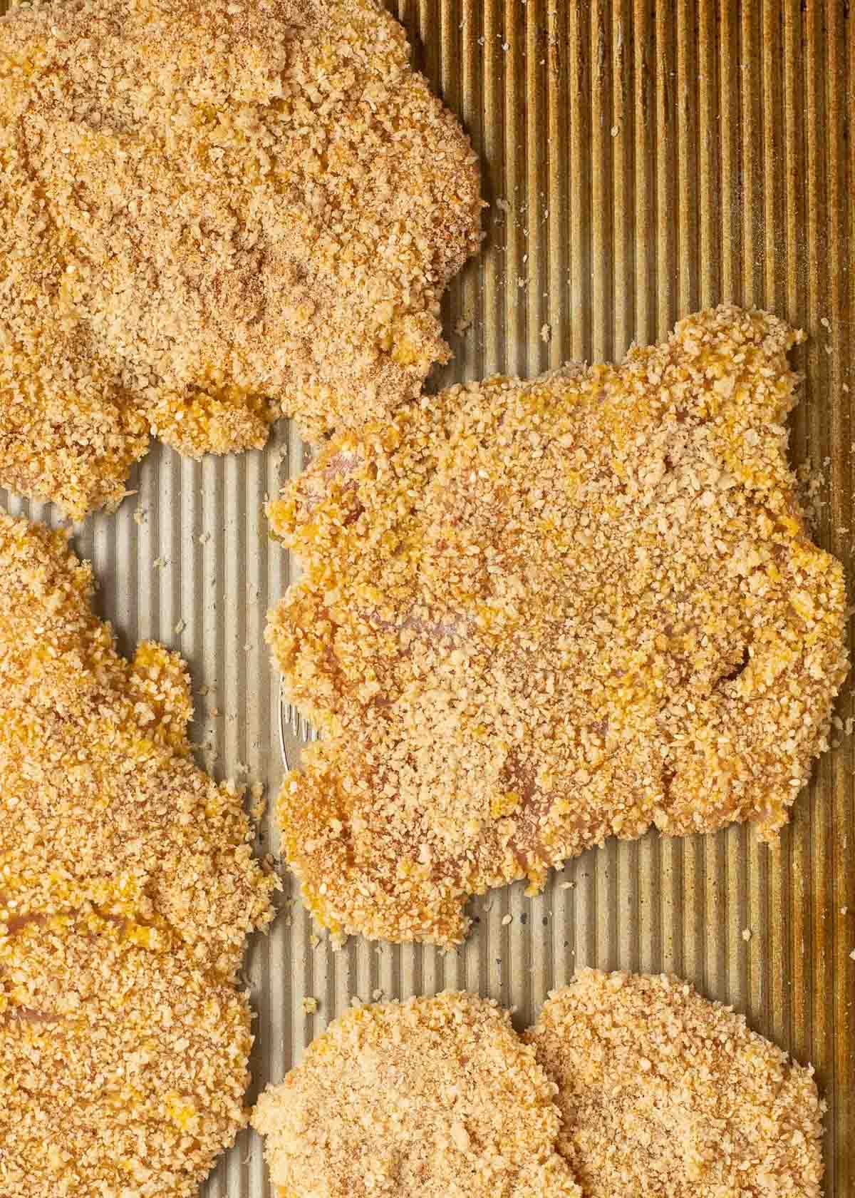 raw, breaded chicken on sheet pan