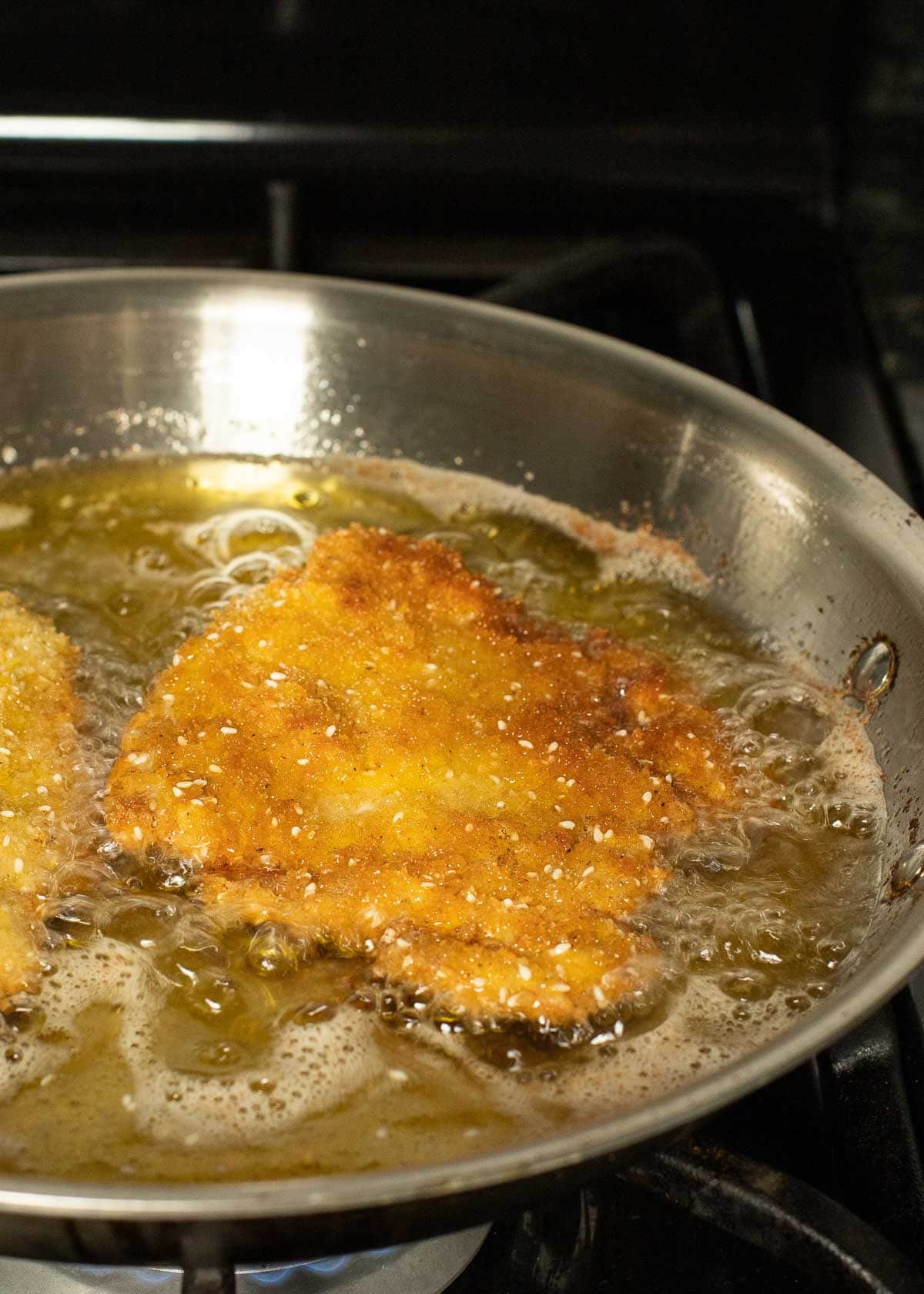 chicken frying in pan