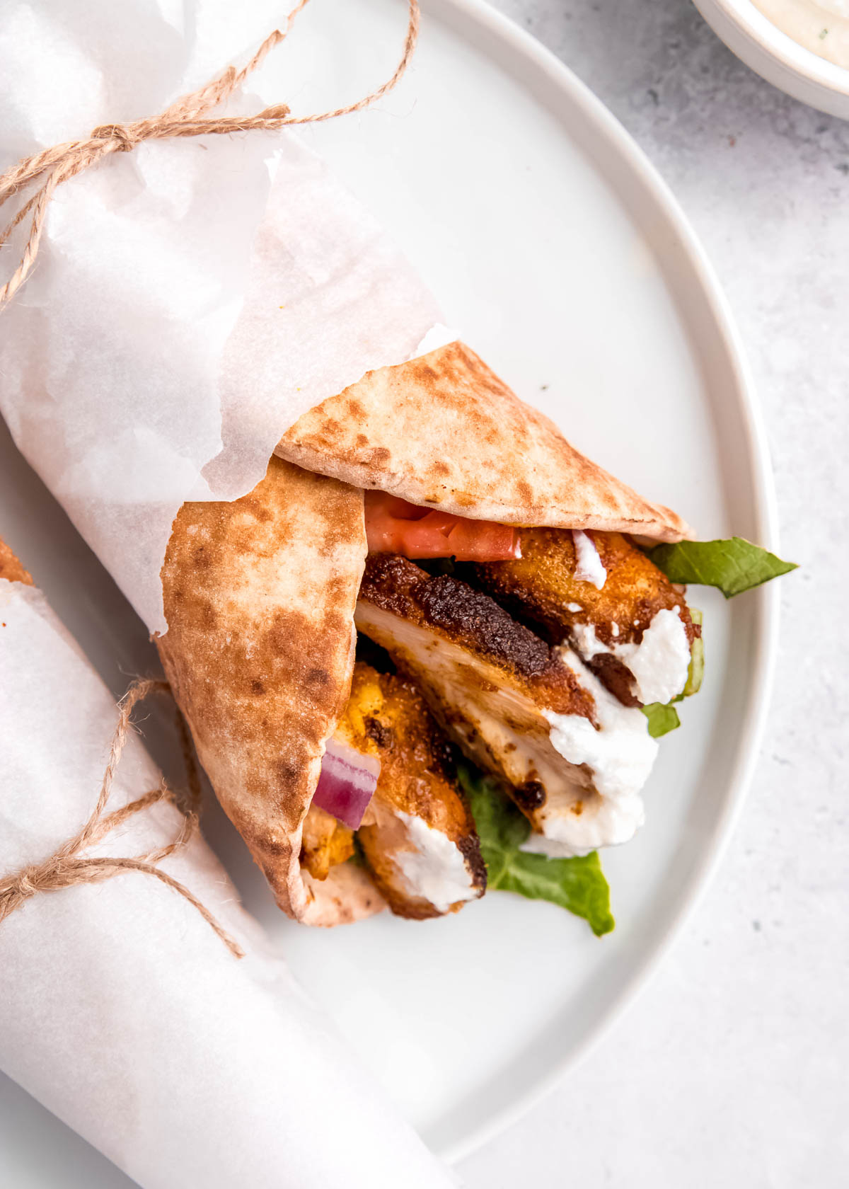 chicken shawarma on a white plate on white table