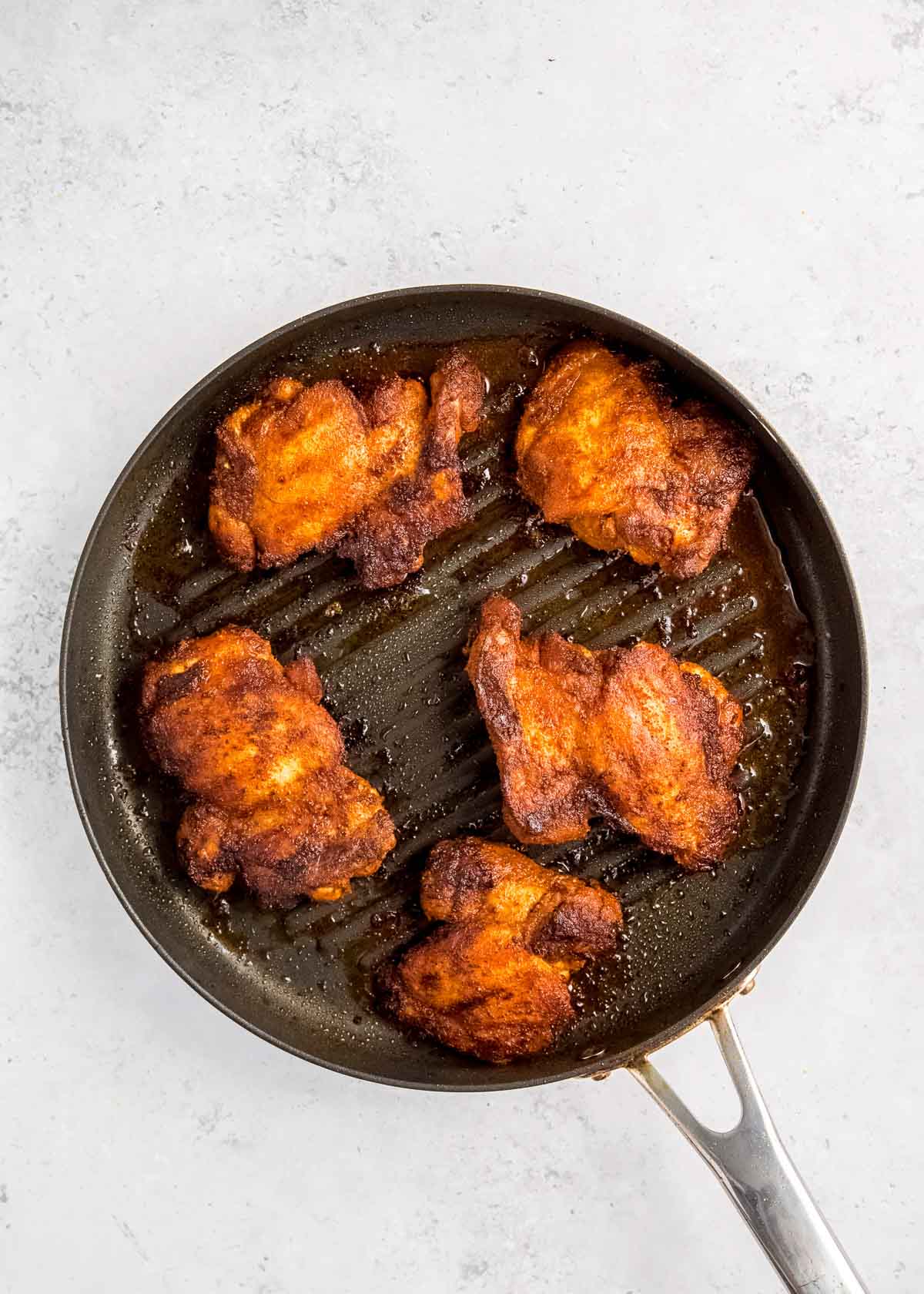 overhead image of chicken being cooked on grill pan