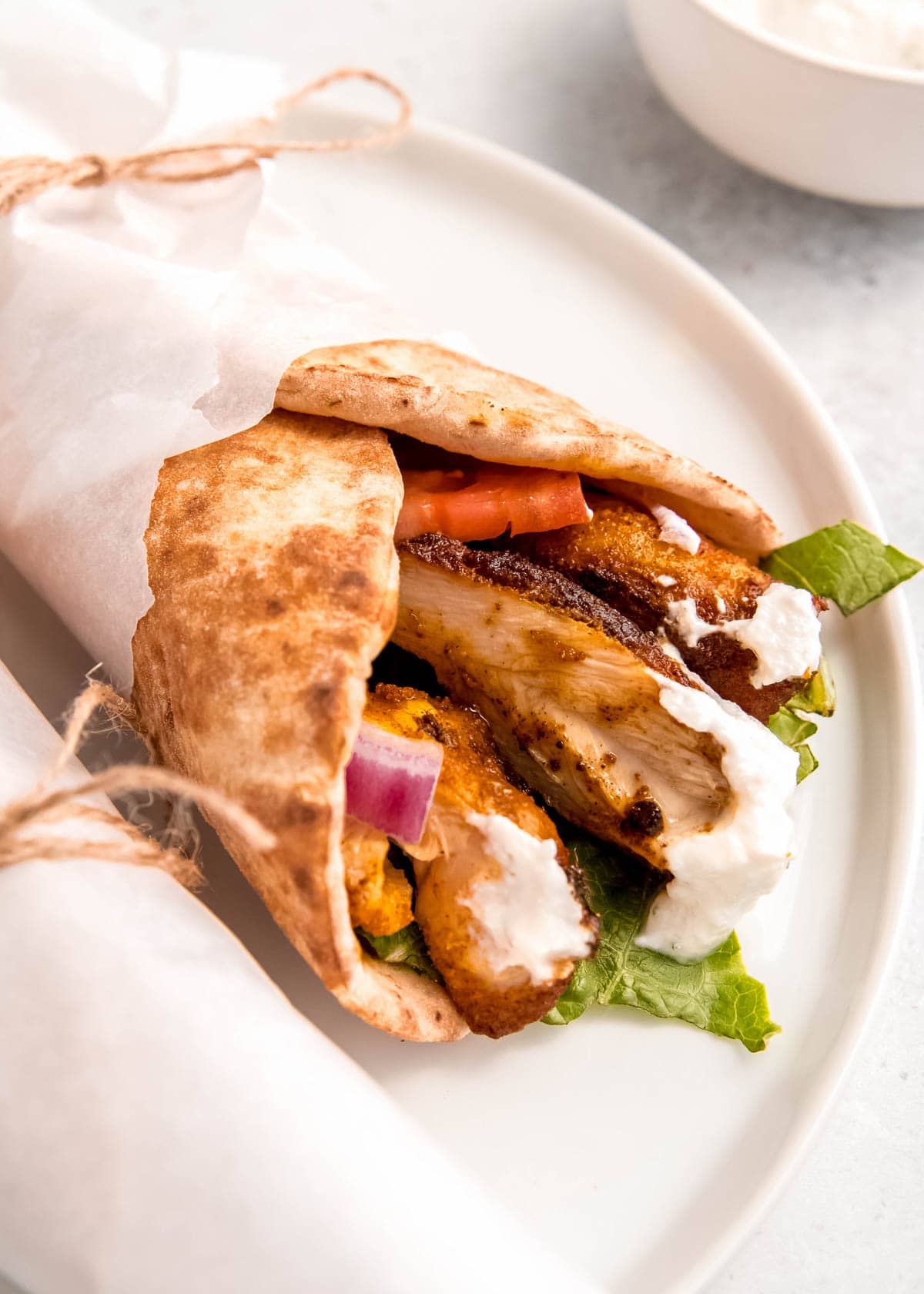 close up image of chicken shawarma on white plate 