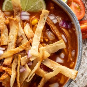 close up image of chicken tortilla soup in gray bowl