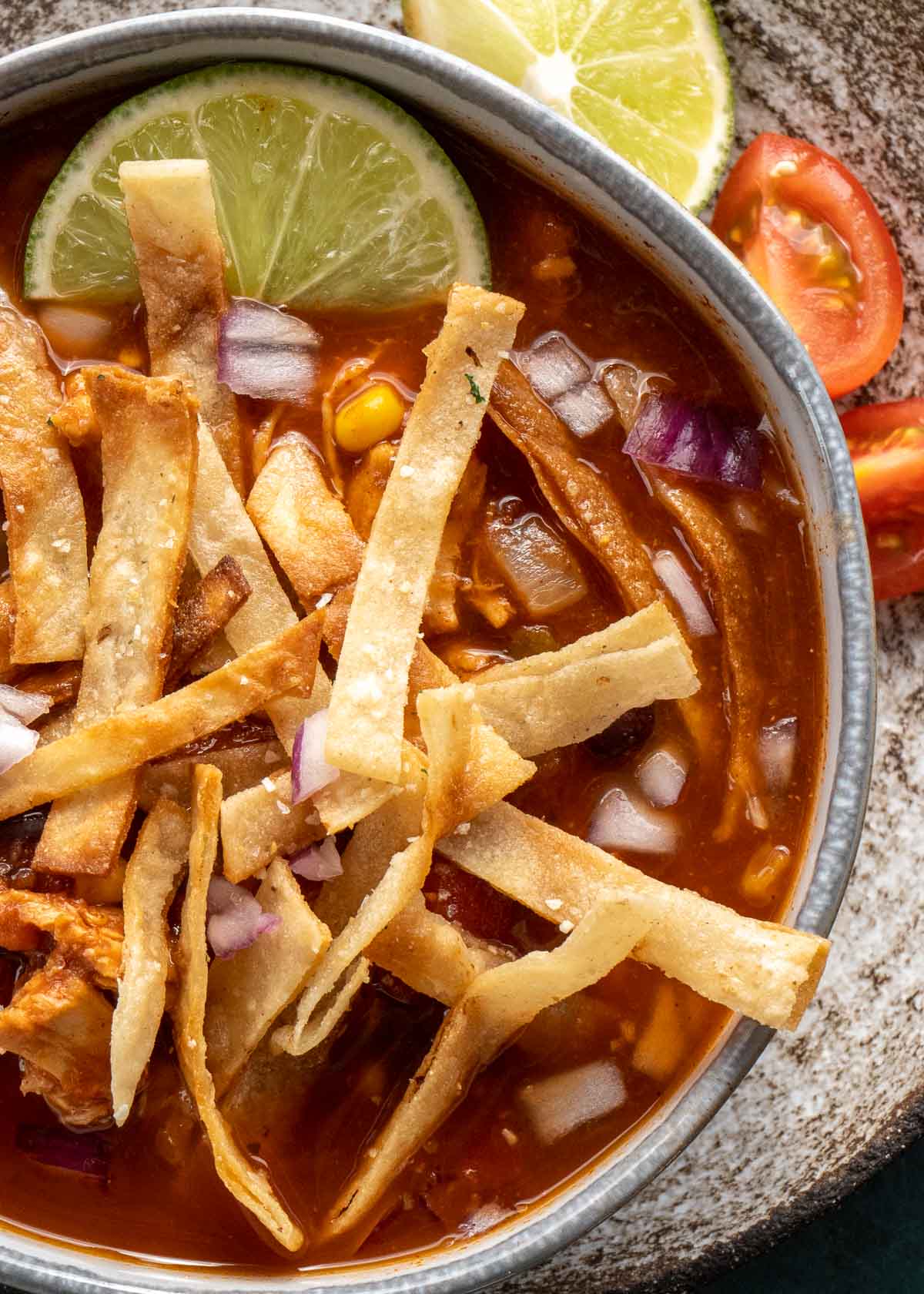 close up image of chicken tortilla soup in gray bowl