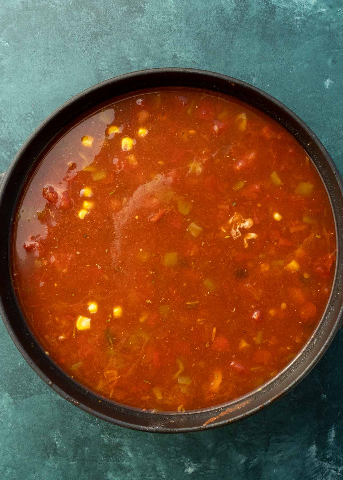 chicken tortilla soup simmering in black dutch oven