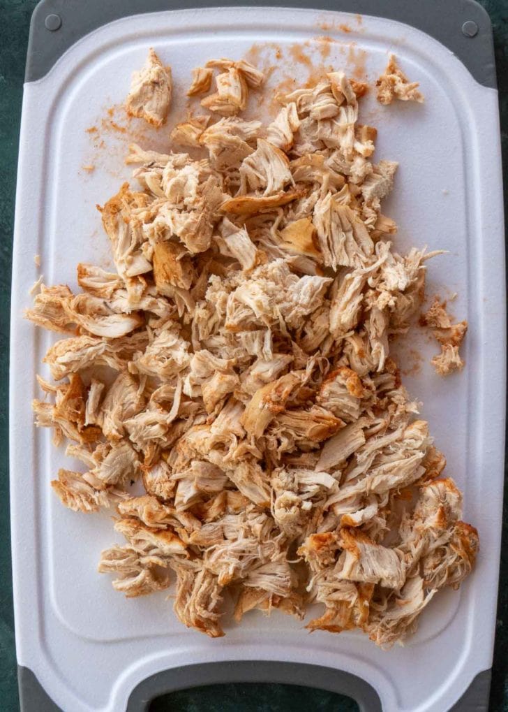 shredded chicken on white cutting board