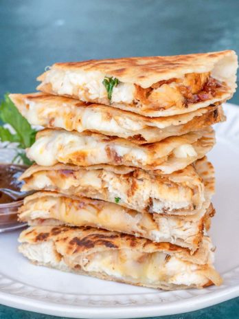 bbq chicken quesadilla slices stacked on a white plate