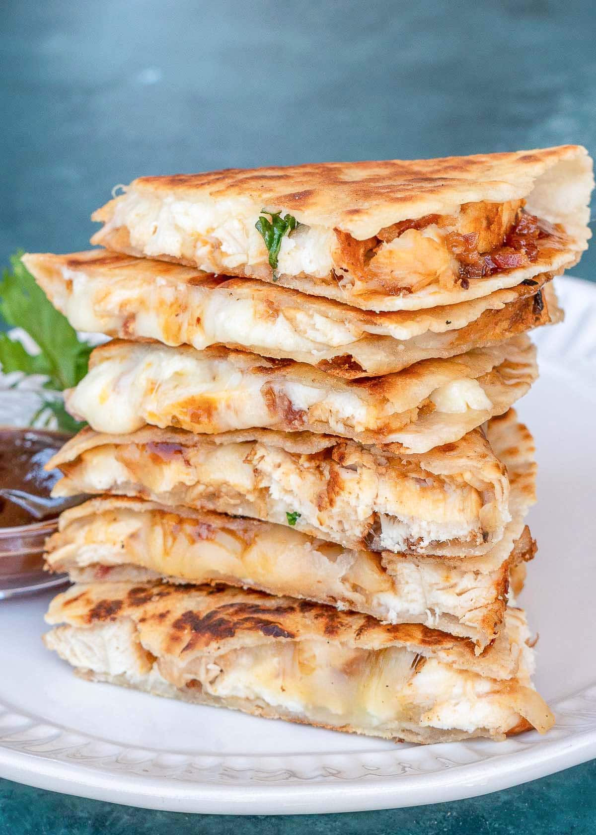 bbq chicken quesadilla slices stacked on a white plate