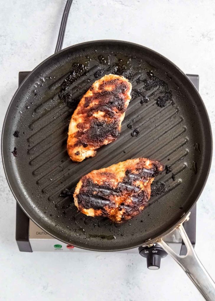 overhead image of chicken being cooked on grill pan