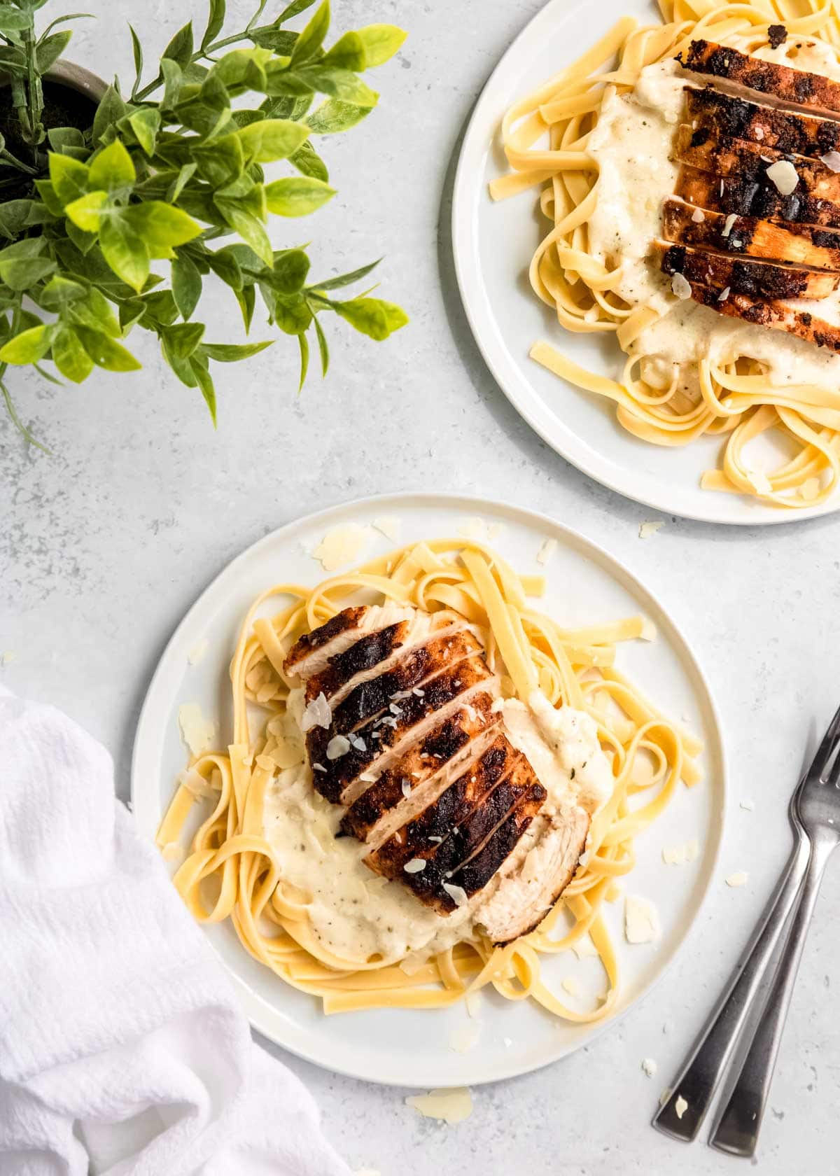 overhead image of chicken alfredo on white plate with fork