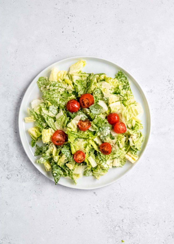 lettuce and cherry tomatoes on a white plate