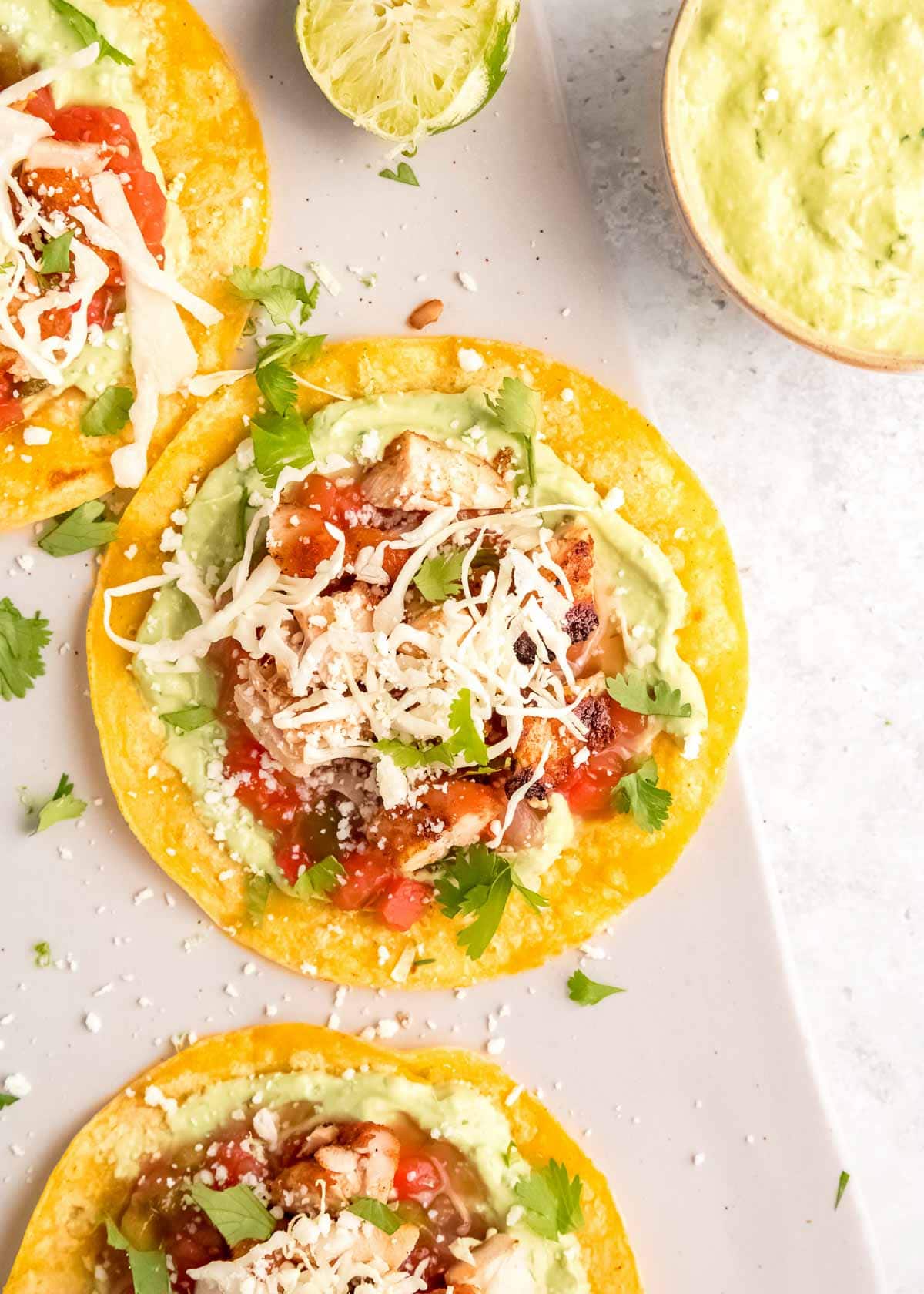 overhead, close image of grilled chicken taco on white cutting board 