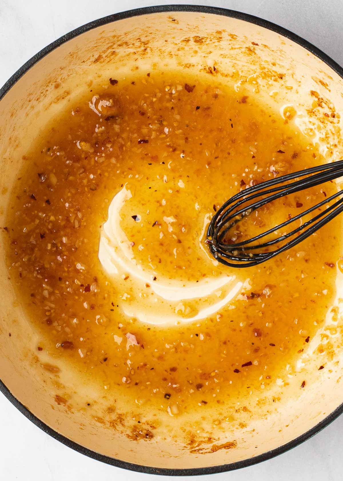 honey mixture being stirred in dutch oven