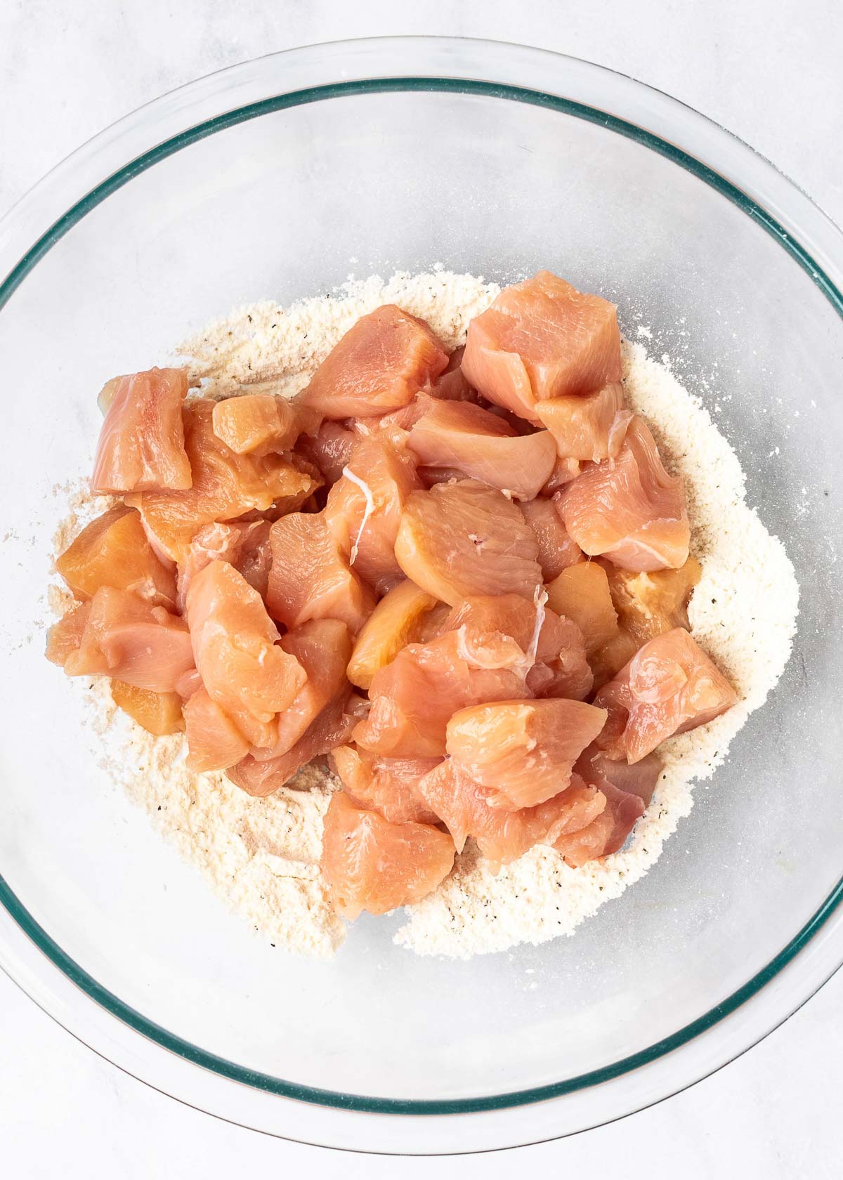 spices, flour, and chicken in a mixing bowl