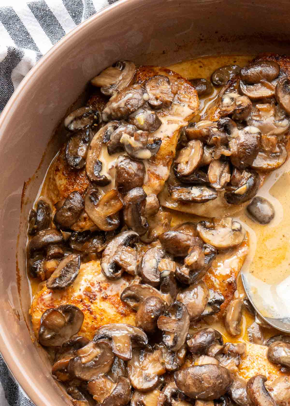 close up overhead image of baked mushroom chicken and spoon