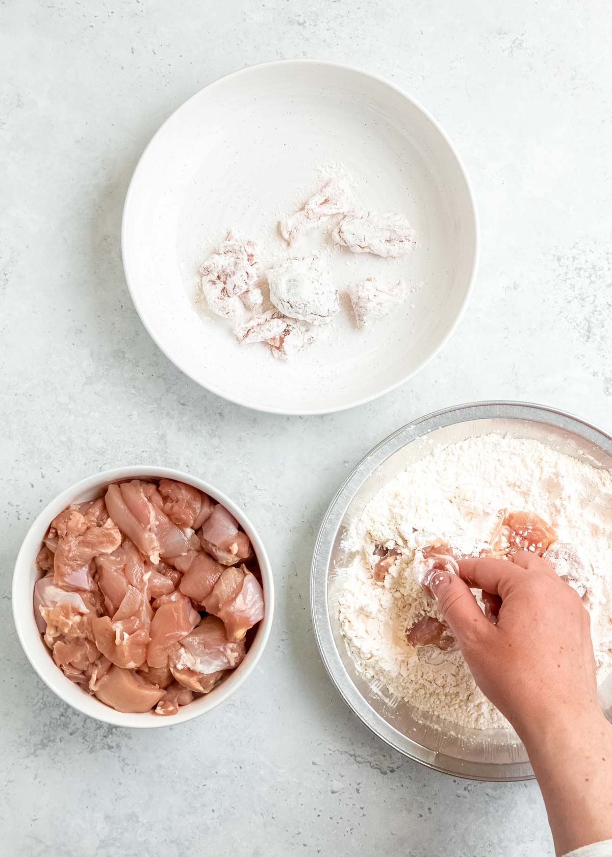 chicken being battered in mixing bowl 