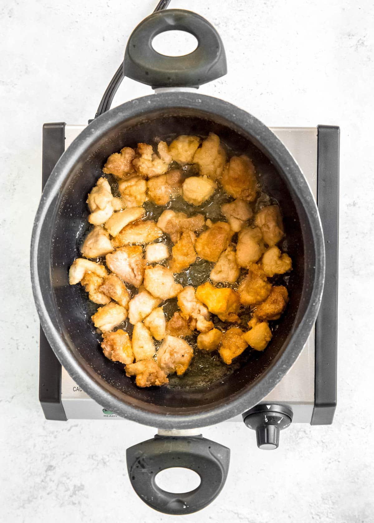 overhead image of chicken being fried 