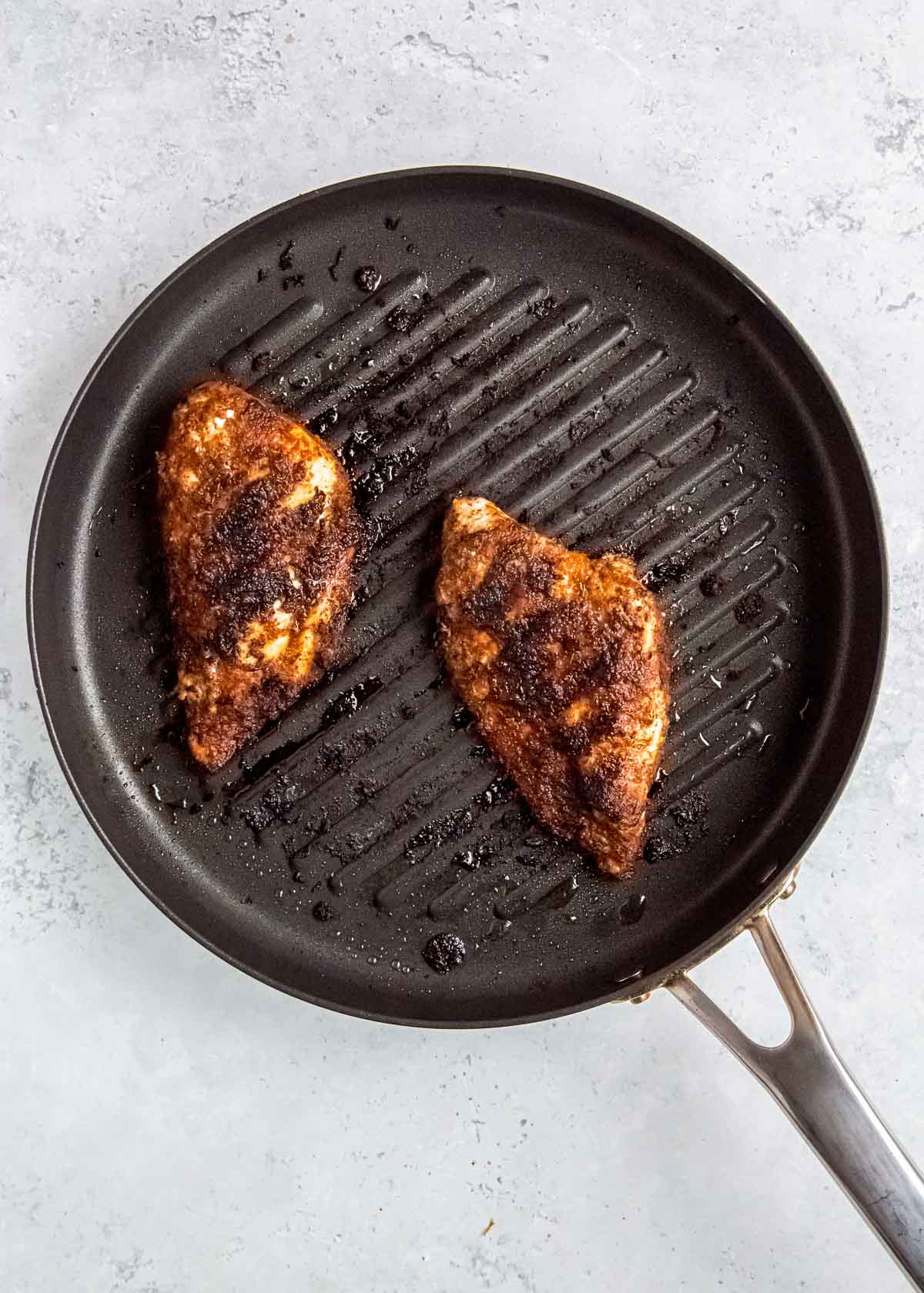 overhead image of cooked chicken in a cast iron skillet 