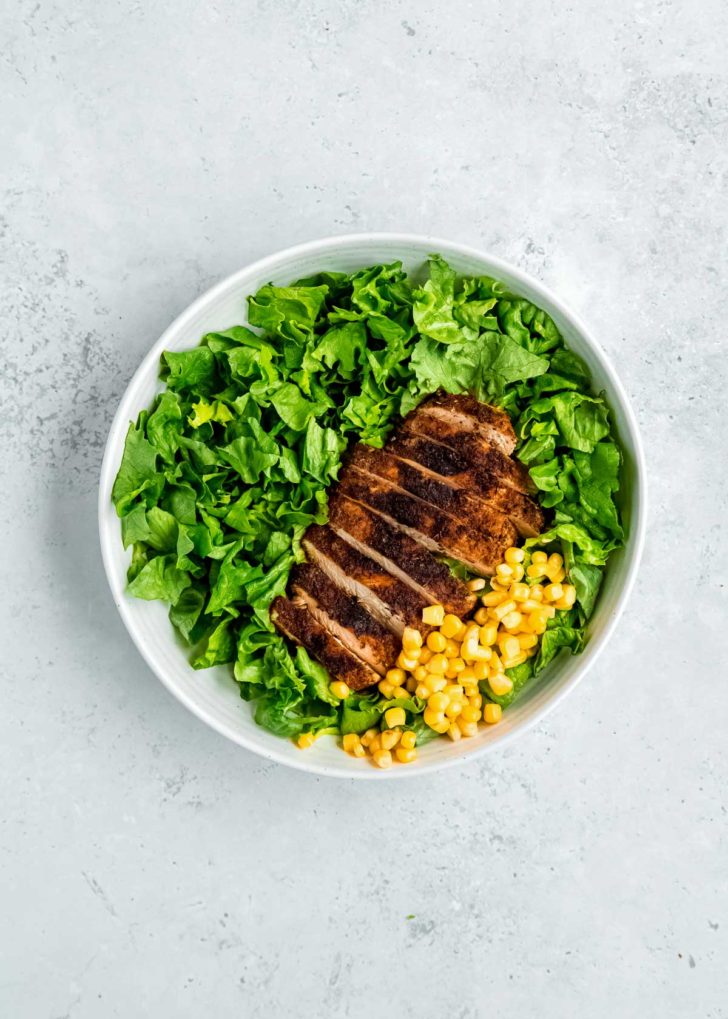 cooked chicken and lettuce in white bowl