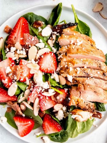 close up, overhead image of strawberry spinach chicken salad on white plate