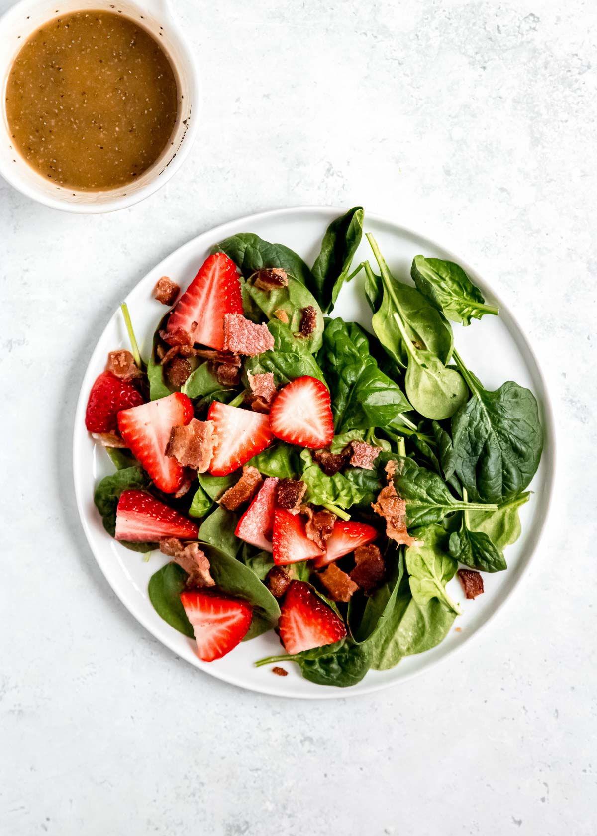 strawberries and spinach on a white plate