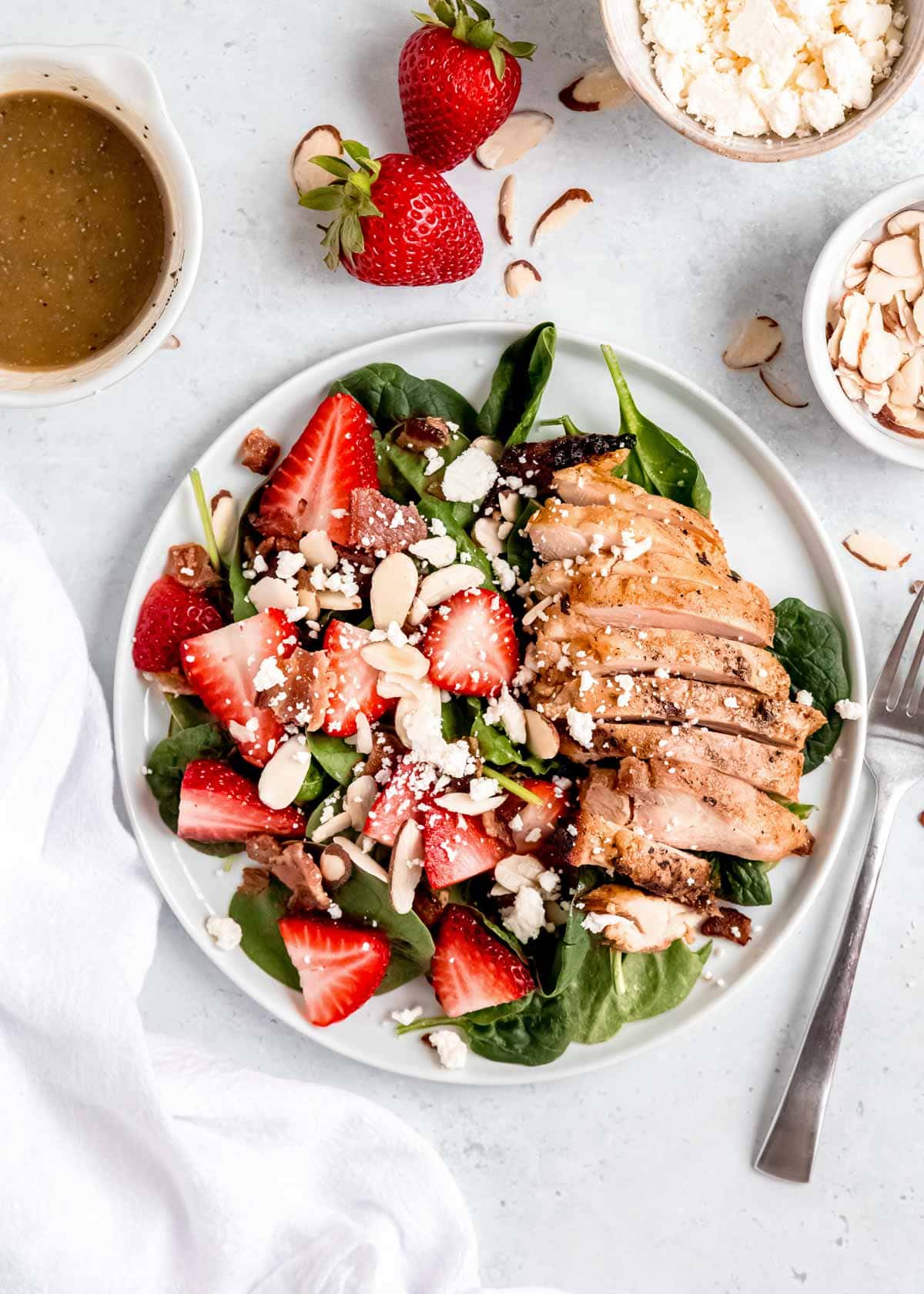 strawberry spinach chicken salad on a white plate