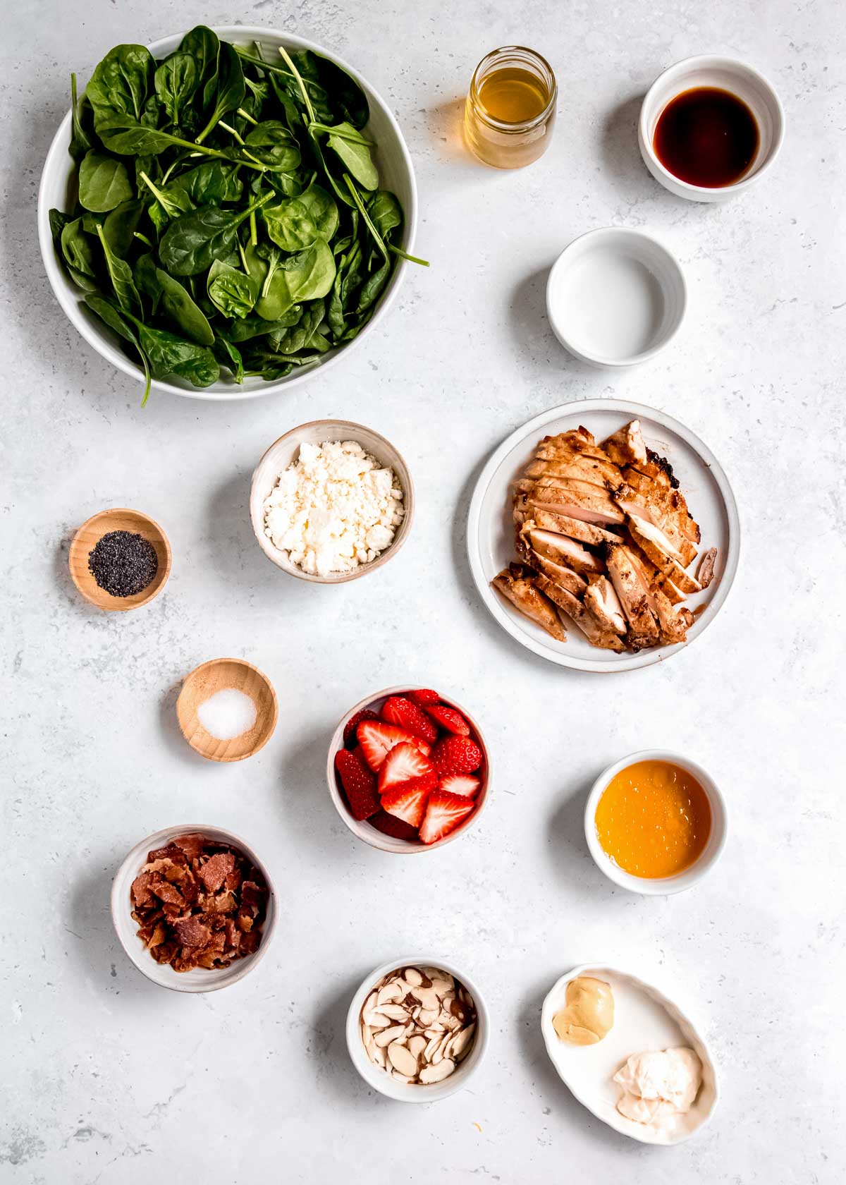 strawberry spinach chicken salad ingredients on a white table 