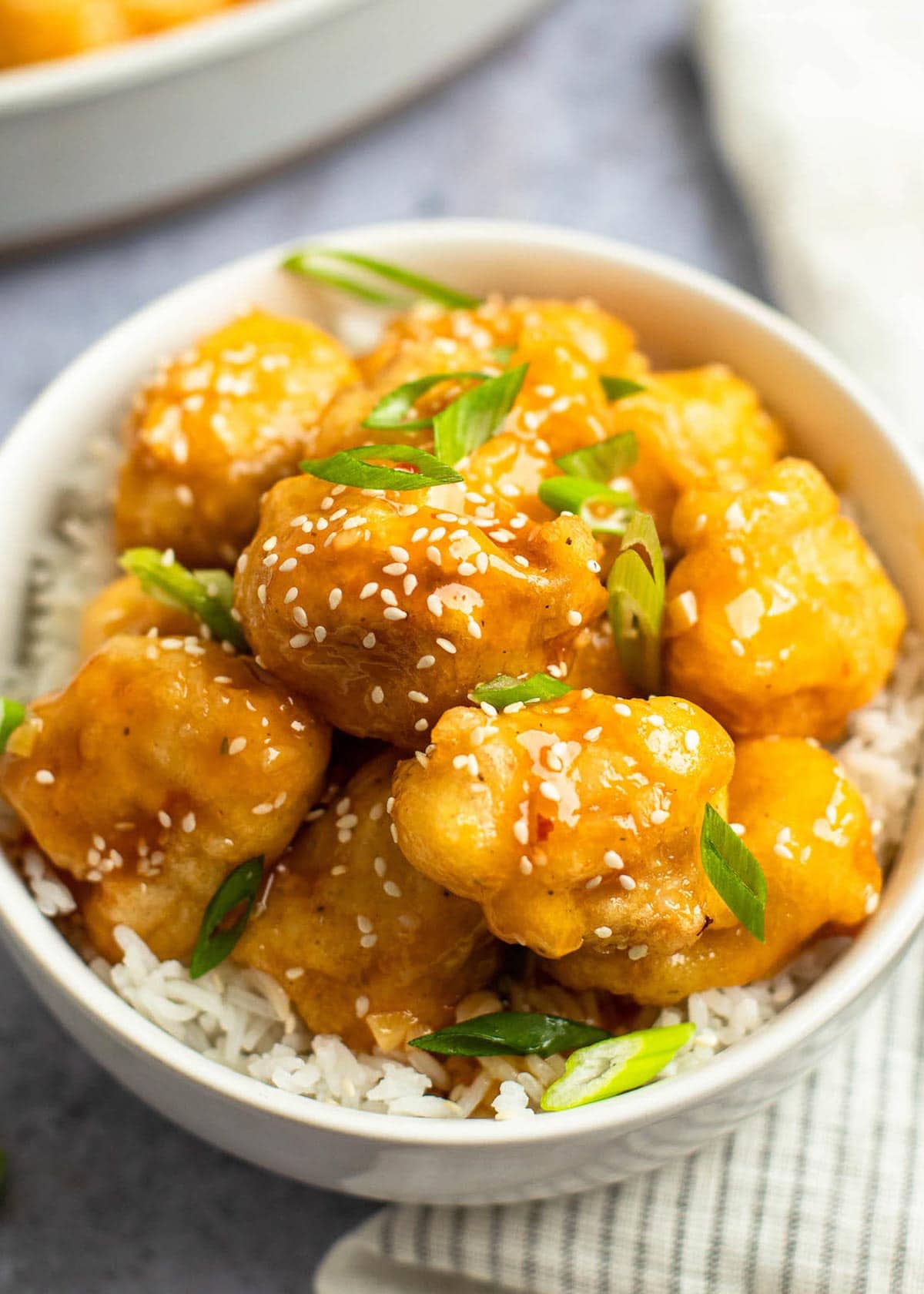 close up, overhead image of sweet and sour chicken in white bowl