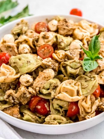 close up image of tortellini pasta salad in white bowl