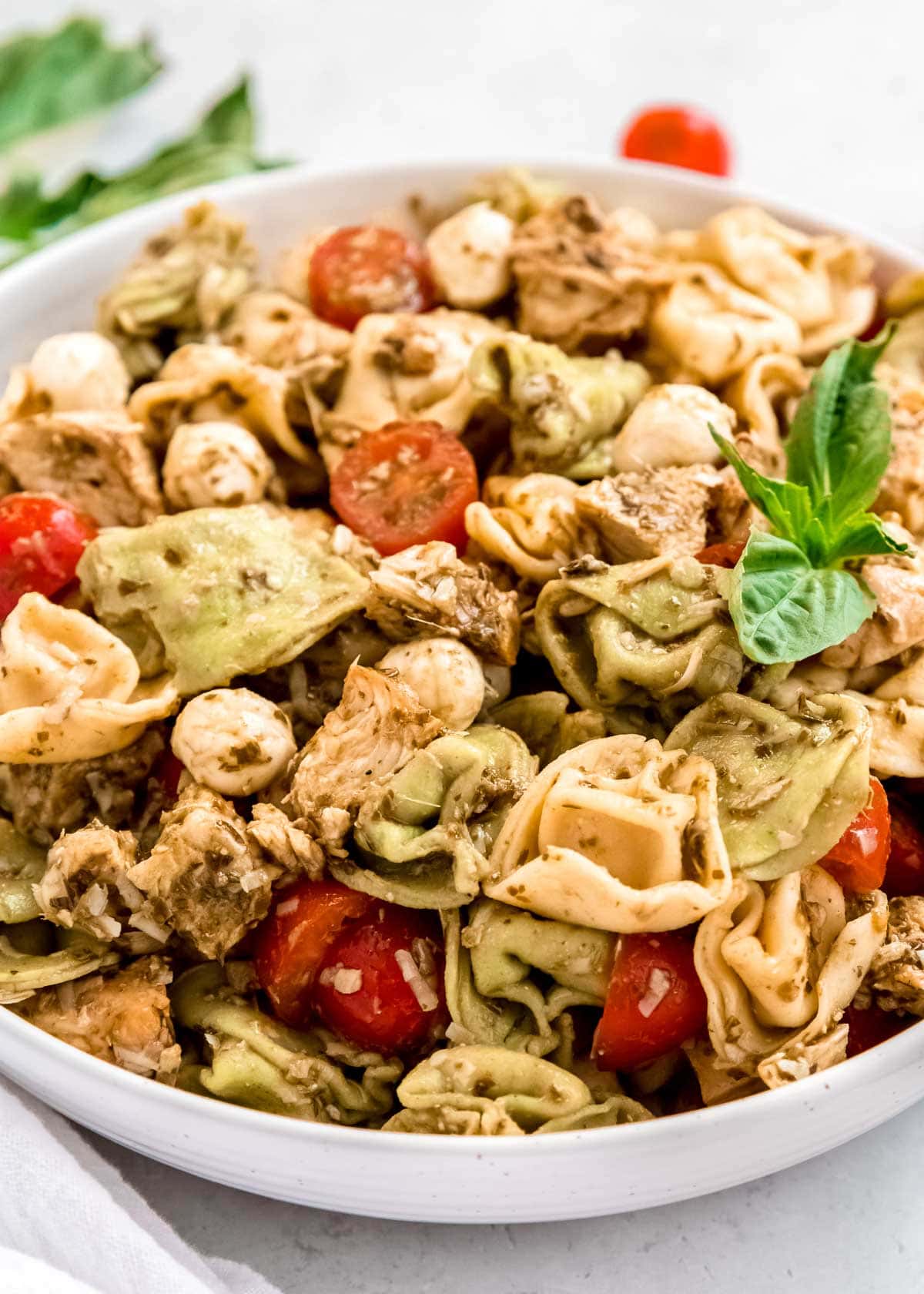 close up image of tortellini pasta salad in white bowl