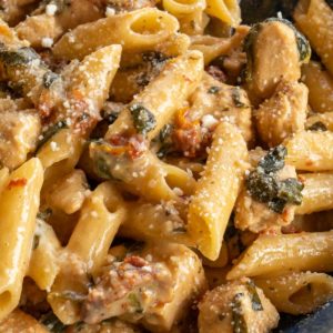 close image of tuscan chicken pasta in blue bowl