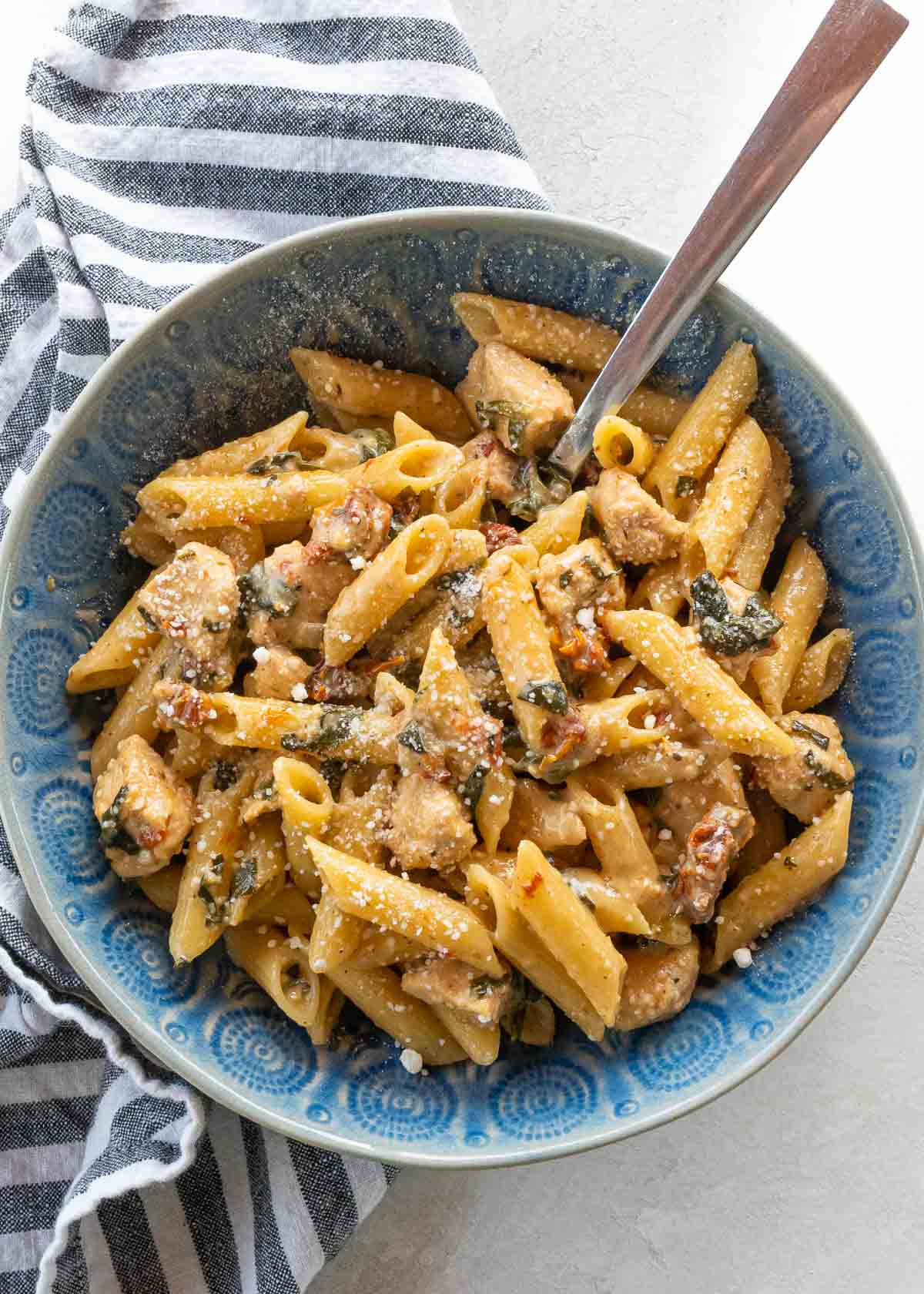 overhead image of tuscan chicken pasta in blue bowl