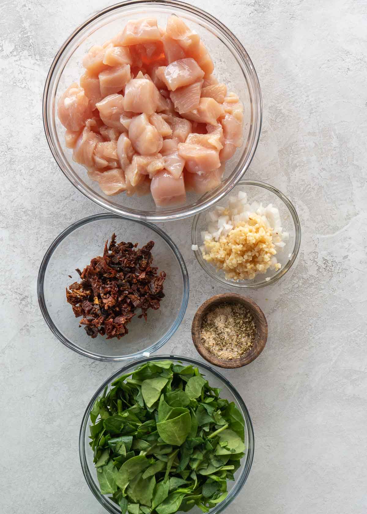 tuscan chicken pasta ingredients on a white table 