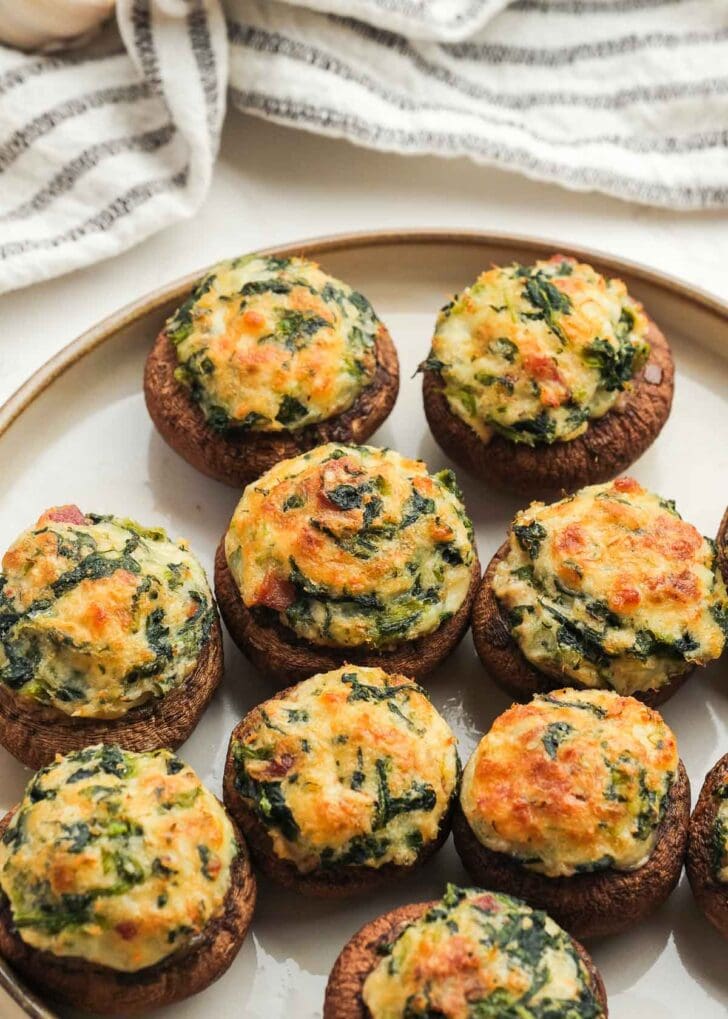 a plate full of crab and bacon stuffed mushrooms