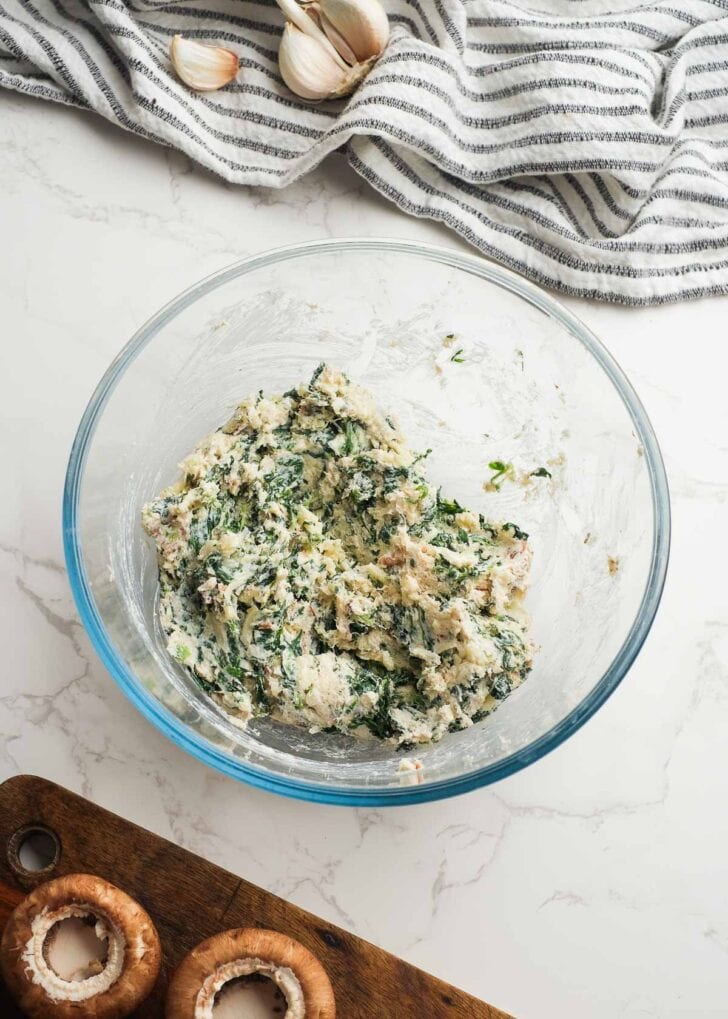 creamy crab and bacon spinach mushroom stuffing mixed together in a glass bowl