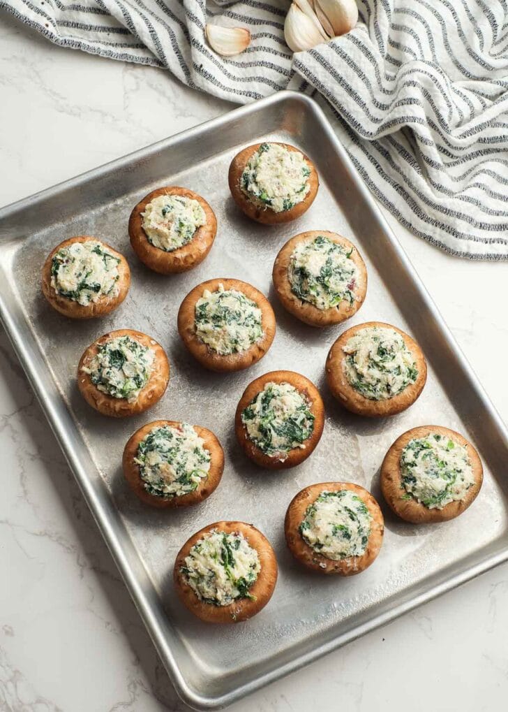 a baking pan lightly greased and filled with crab and bacon stuffed mushrooms