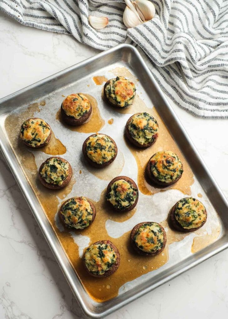 cheesy crab stuffed mushrooms on a baking pan