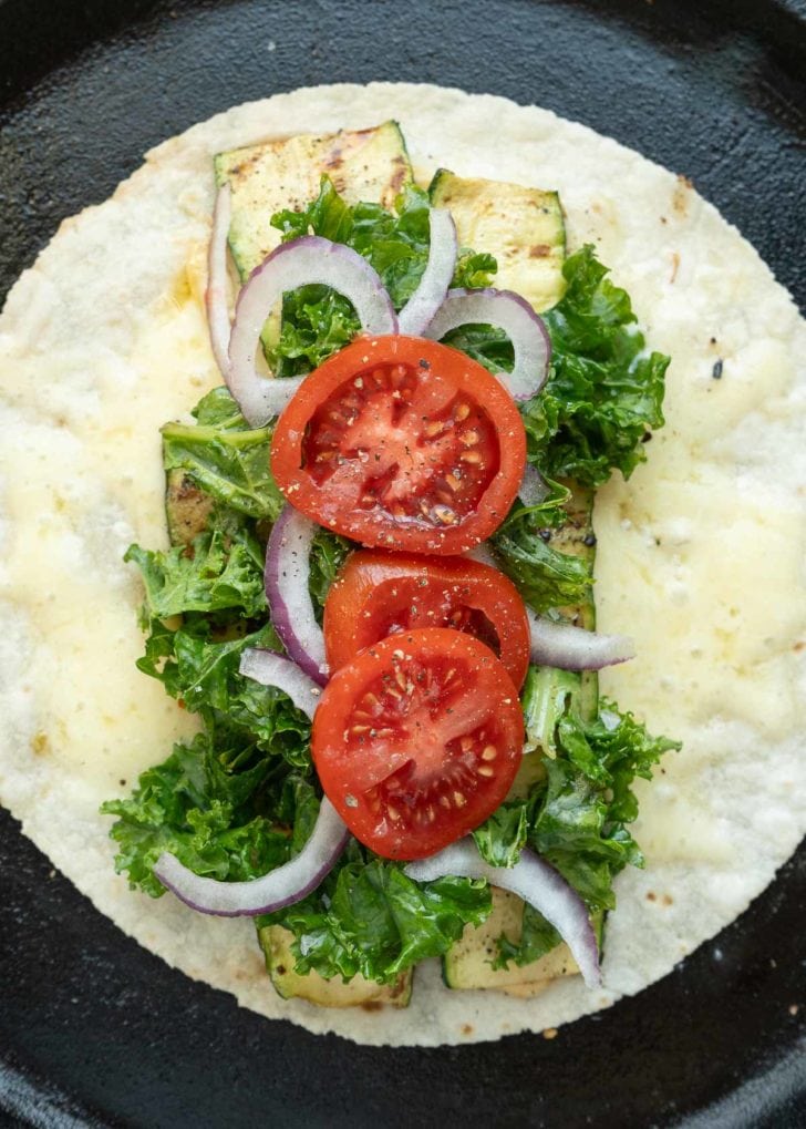 grilled zucchini, kale, tomatoes and red onion on a tortilla