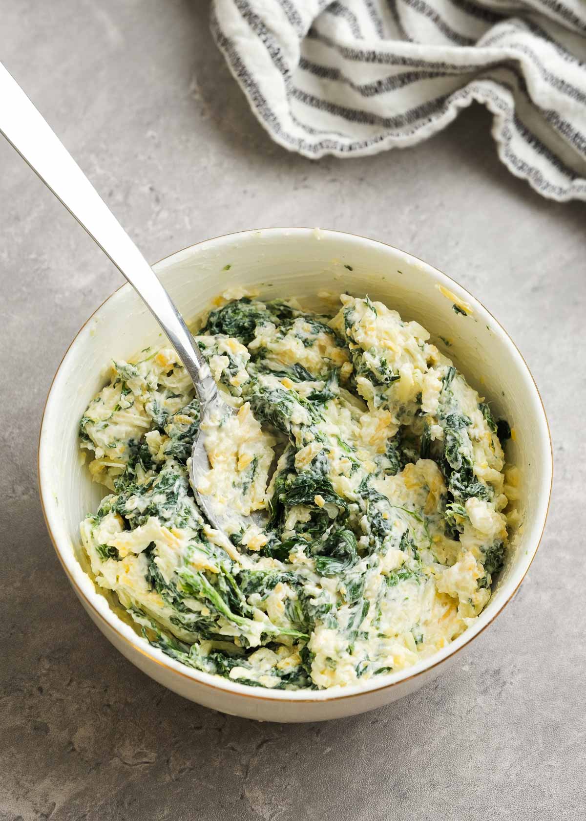 a white bowl with the filling for spinach stuffed chicken