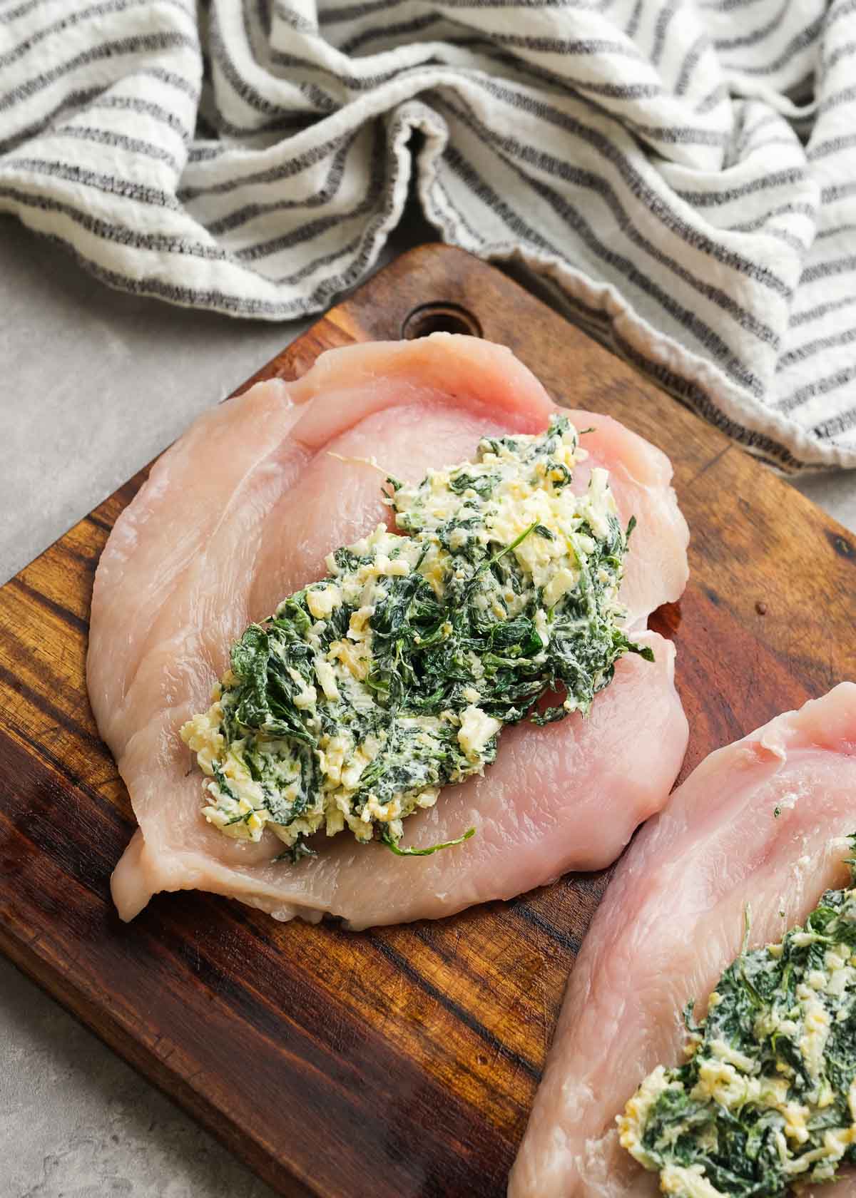 a chicken breast cut open filled with a spinach and cheese mixture