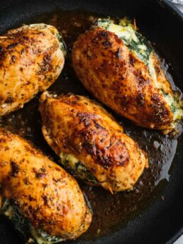 spinach and cheese stuffed chicken in a skillet