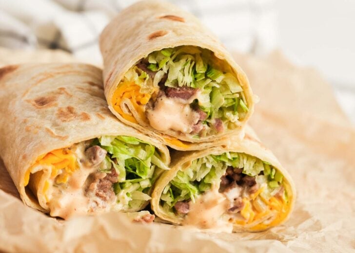 three big mac wraps cut in half to show the fillings including lettuce, cheese, meat, and sauce